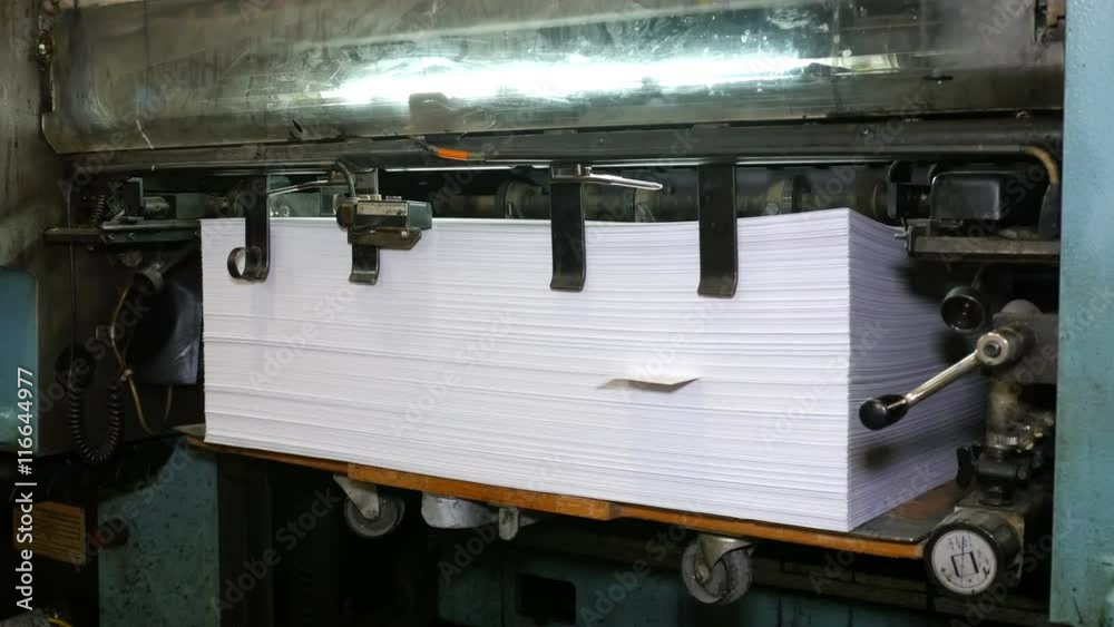 Printed sheets of paper laid in pile after being rolled out of printing press. Related to technology of publishing, offset press. Close-up shot. 4K Ultra HD. Printed sheets of paper laid in pile after being rolled out of printing press. Related to technology of publishing, offset press. Close-up shot. 4K Ultra HD.
