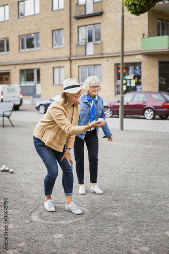 Wallpaper Mural Senior women playing boule on field by street against buildings Torontodigital.ca