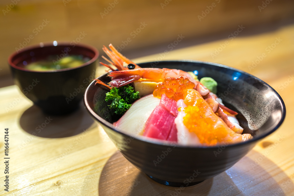 Chirashi sushi, Japanese food, rice bowl with raw salmon sashimi, tuna,  scallop, shrimp, surf clam, salmon eggs, served with miso soup, focus on  salmon eggs with depth of field effect foto de