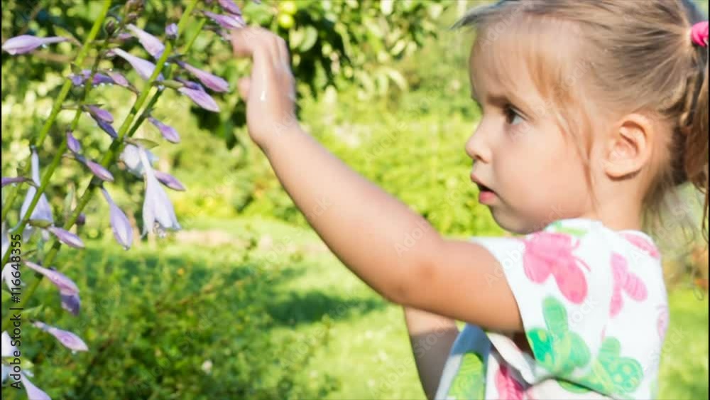girl playing with a flower and looking at the camera. large eyes of a child girl playing with a flower and looking at the camera. large eyes of a child