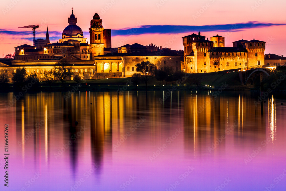 Europe Italy Mantova-Mantua ancient castle at the river reflecting in still waters at sunset highly illuminated by lights