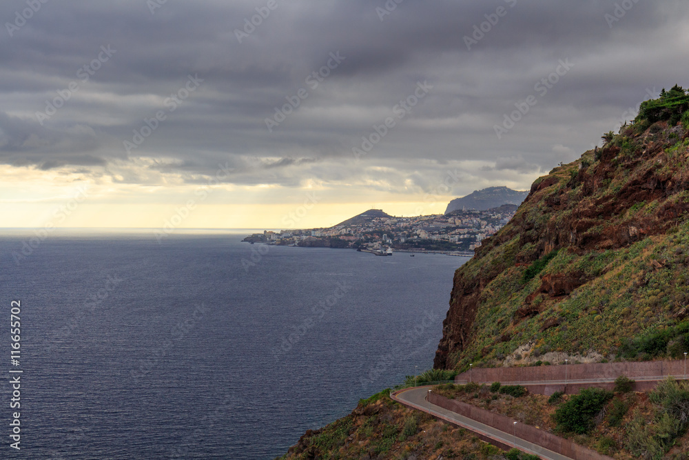 Funchal coastline under the typical cloudy sky before sunset.