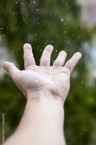 Feel the rain on your skin, white male palm catching rain drops