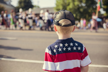 Child watching an Independence Day Parade on a summer day