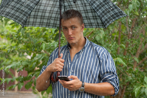 Man with umbrella and mobile phone