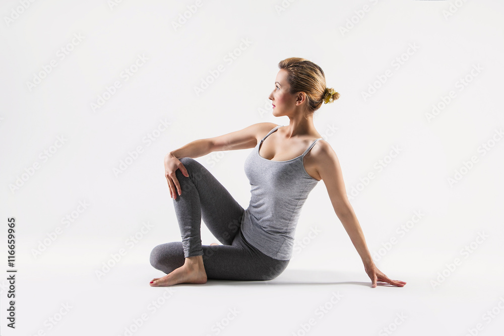 Fototapeta premium Beautiful young woman doing yoga. Isolated on white