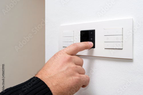 Closeup shot of man's hand controlling multipurpose switch photo