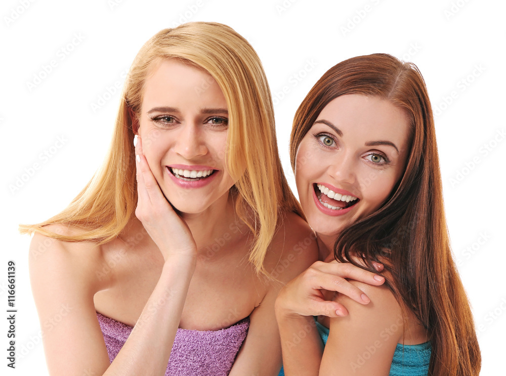 Two beautiful women wrapped in towel isolated on white Two beautiful women wrapped in towel isolated on white