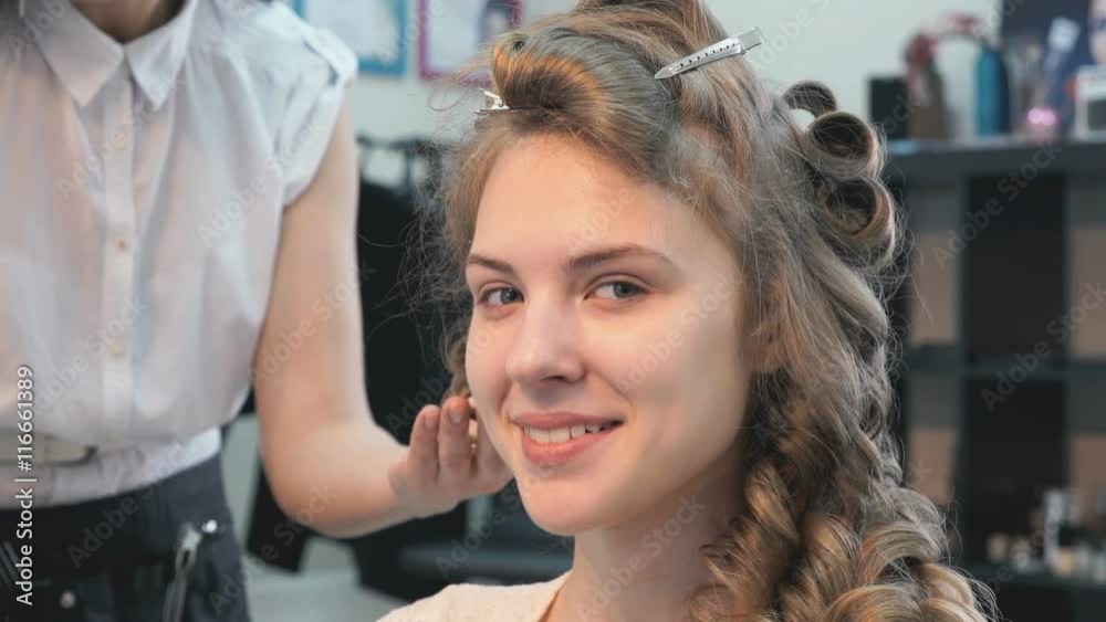 Master making hairstyle a girl at the beauty salon Master making hairstyle a girl at the beauty salon