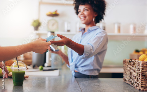 Female employee taking payment from customer photo