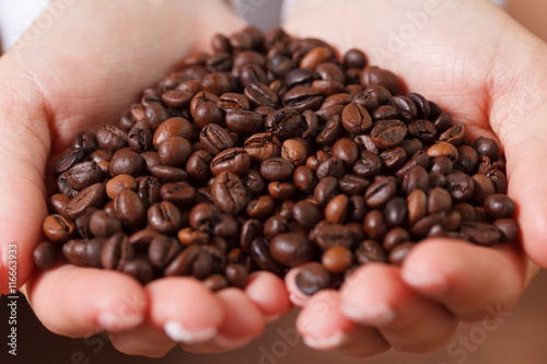 Female hands with coffee beans