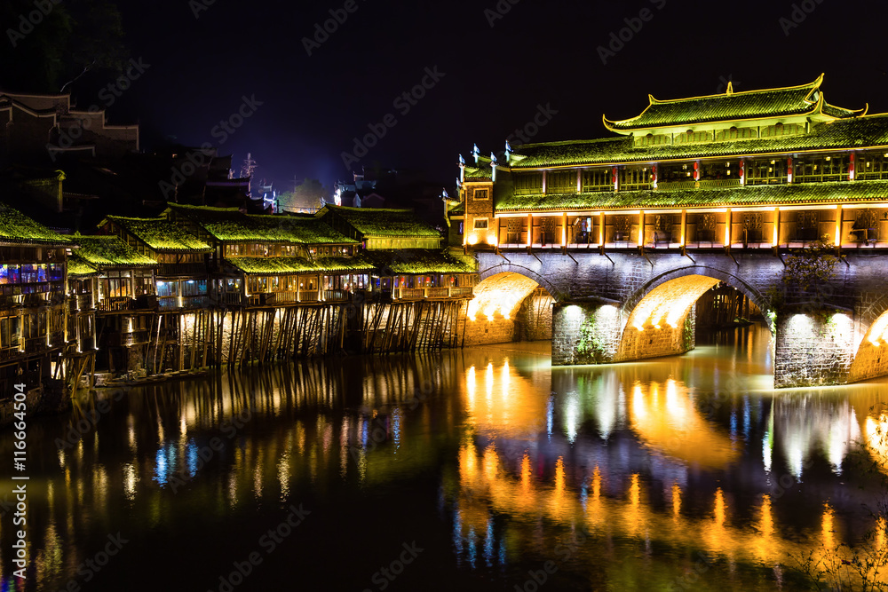 Hong Bridge at night in Fenghuang Ancient town, Hunan province, China. This ancient town was added to the UNESCO World Heritage Tentative List in the Cultural category.