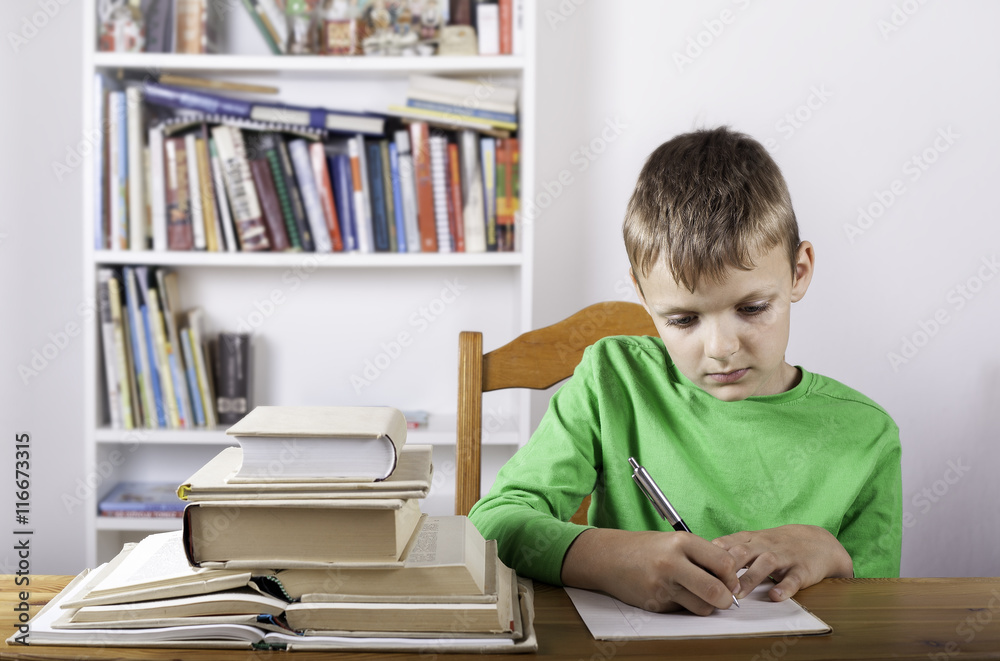Student boy with book writing to notebook at home Student boy with book writing to notebook at home