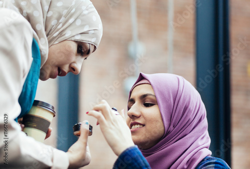 Female friends discussing over sushi at railroad station photo