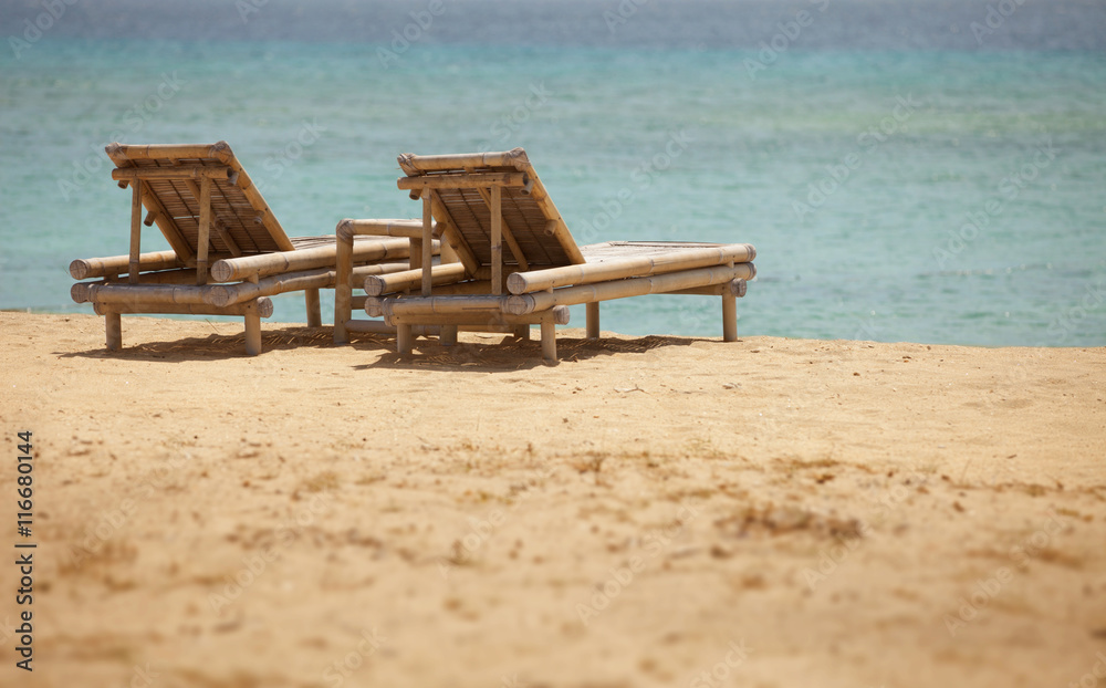 Fototapeta premium Two bamboo deck chairs in retro style