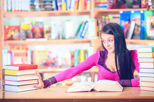 girl student with glasses reading books in the library