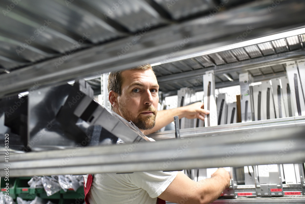 Arbeiter in einem Warenlager - Closeup zwischen Regalen // workers in a warehouse - closeup between shelves Arbeiter in einem Warenlager - Closeup zwischen Regalen // workers in a warehouse - closeup between shelves