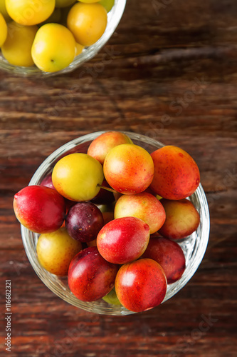 Ripe plums in a glass. Dark wood background