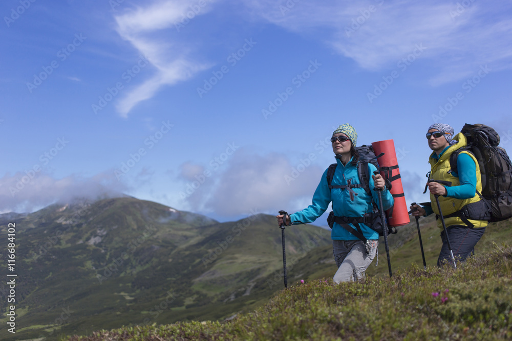 Summer hiking in the mountains with a backpack .