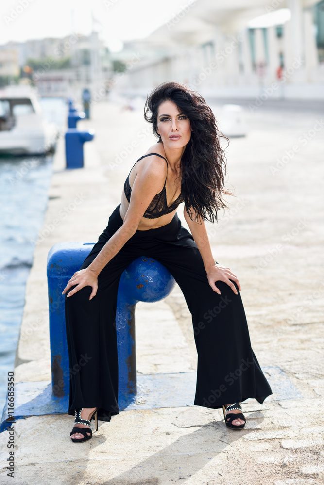 Fototapeta premium Brunette woman wearing black bra and trousers