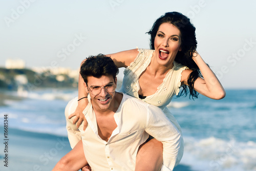 Young happy couple walking in a beautiful beach