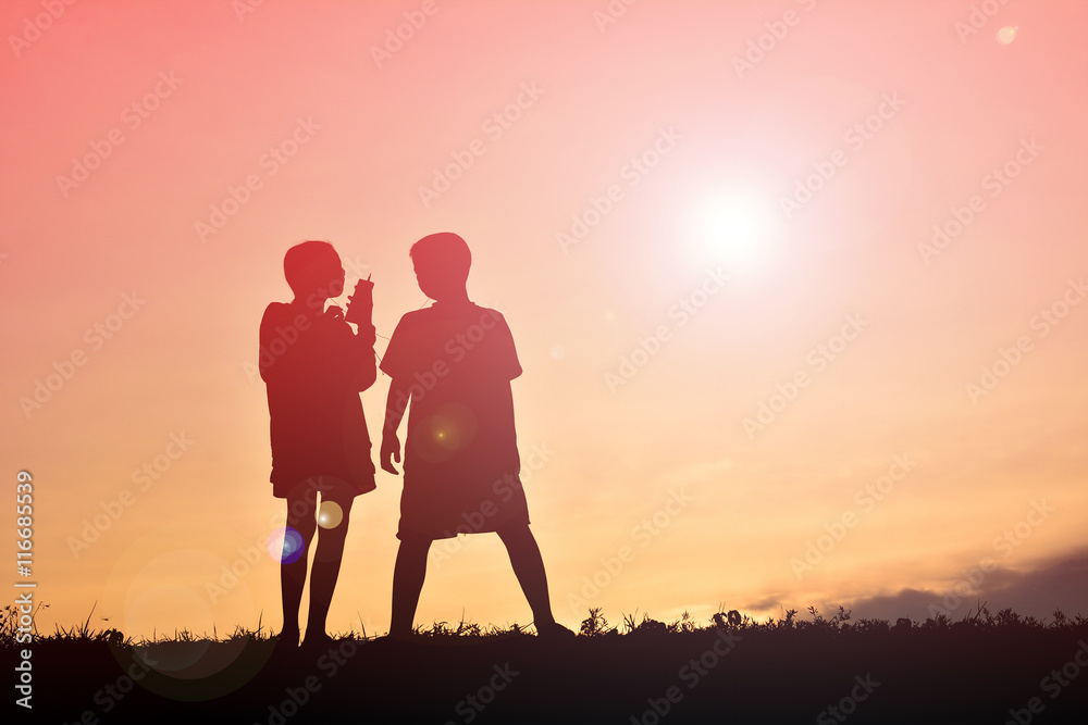 Silhouette children with smartphone at sunset Silhouette children with smartphone at sunset