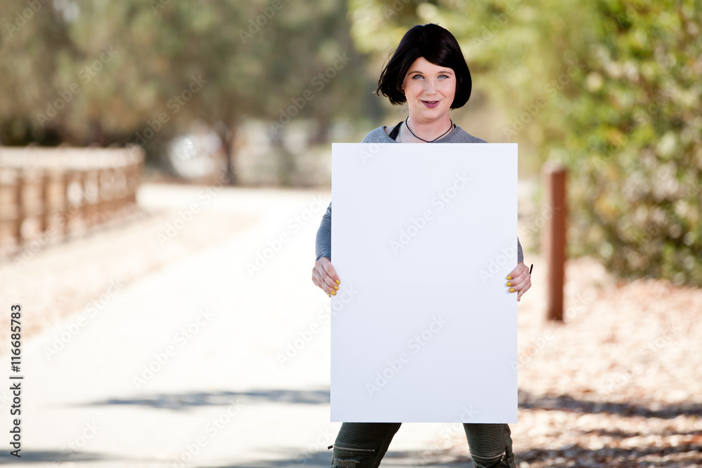Transgender girl holding blank poster board sign for hashtag trans rights issues or awareness phrases. Transgender girl holding blank poster board sign for hashtag trans rights issues or awareness phrases.
