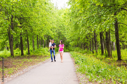 Happy young family walking in the park. Healthy lifestyle concept