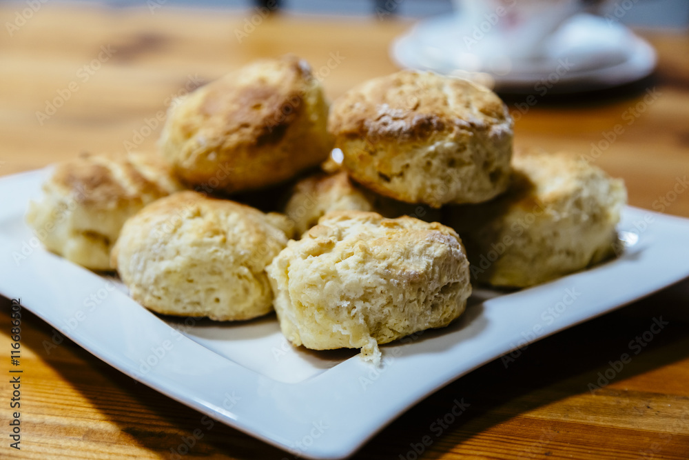 Homemade scones on white plate on wooden table