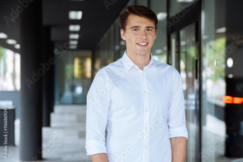 Smiling businessman standing near business center © Drobot Dean