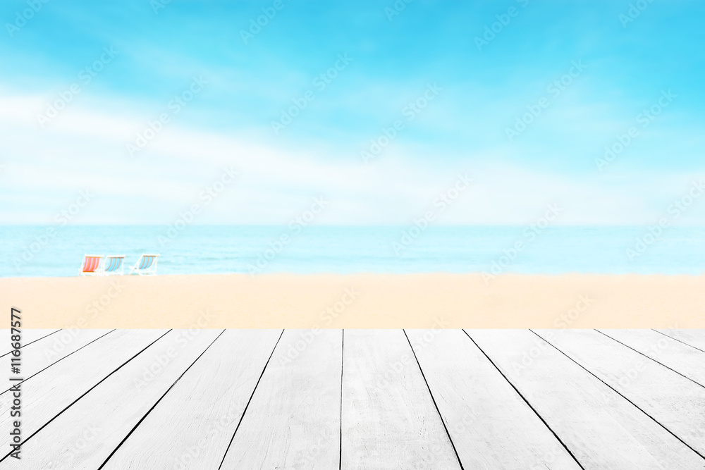 Wood floor with white blue surfing wave background. Blue cool water and sky bright with ray light. Nature wallpaper blur of sea daytime. Focus to wooden in the foreground. Timber pattern texture stage