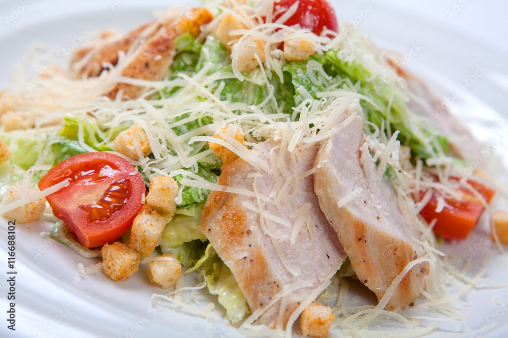Caesar salad with chicken on white plate. Caesar salad with chicken on white plate.