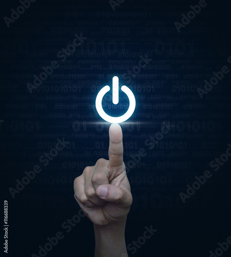 Hand pressing power button over computer binary code blue backgr