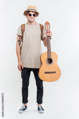 Handsome young man in sunglasses playing on the guitar