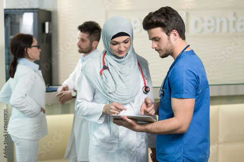 Saudi arab doctors working with a tablet.