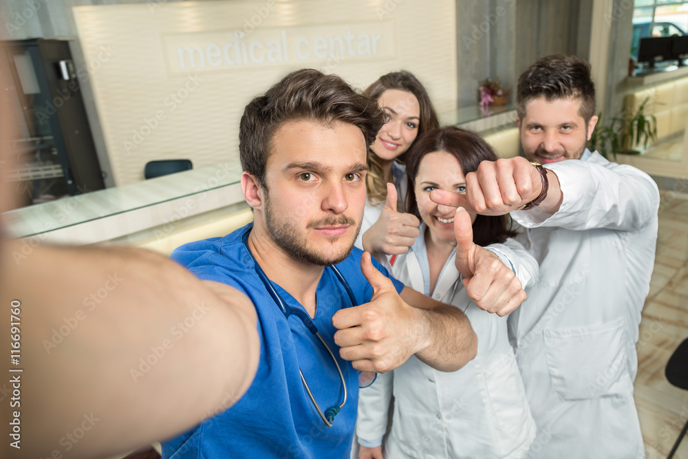 Obraz premium Smiling Team Of Doctors And Nurses At Hospital Taking Selfie