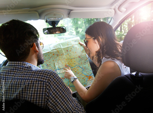 Happy young couple with a map in the car. They are using map on road trip. © Zoran Zeremski