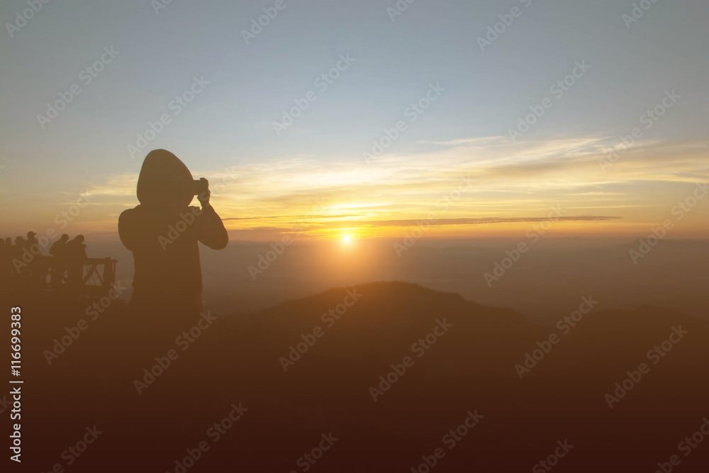 Silhouette of a woman photographed the sunrise.