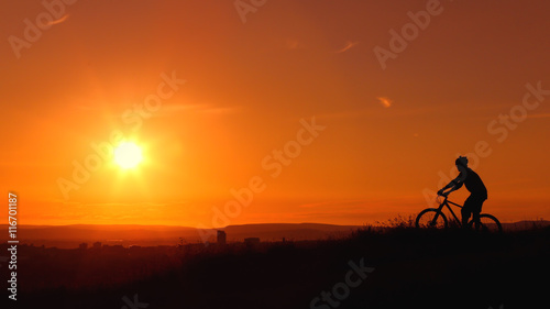 A cyclist enjoys a picturesque sunset.