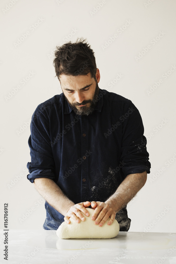 Baker kneading and shaping a portion of bread dough into a ball. Baker kneading and shaping a portion of bread dough into a ball.