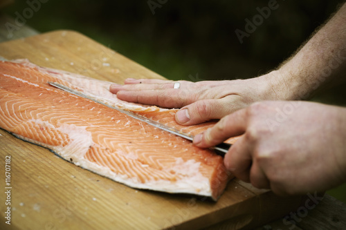 Close up of a chef filleting a fresh salmon.
