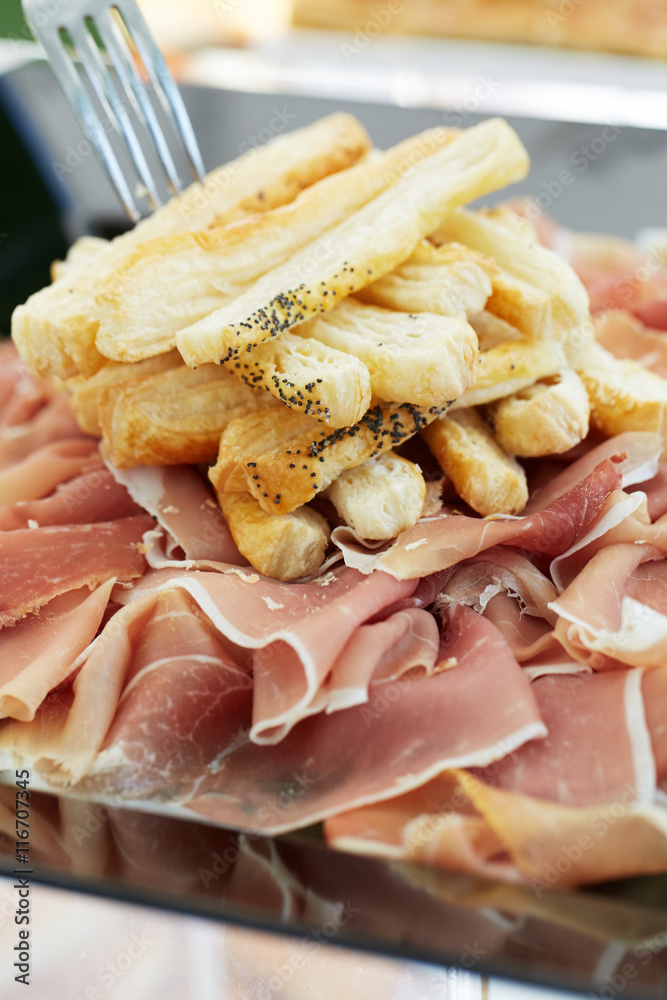 Prosciutto, traditional italian cured ham with slices of bread