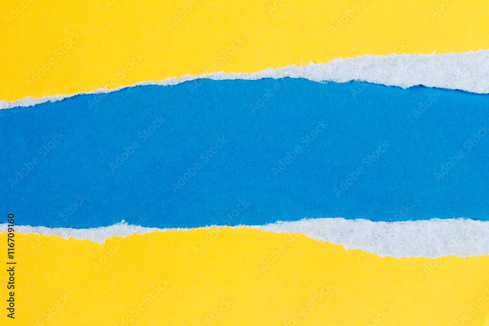 Obraz premium Podarty papier żółty na niebieskim tle