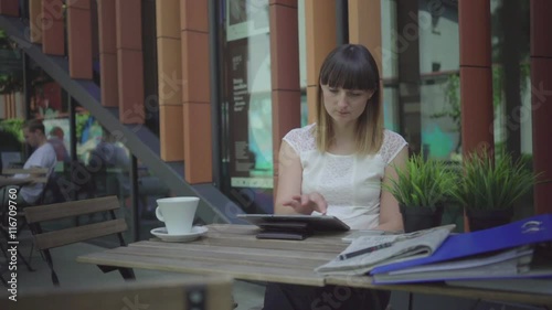 Businesswoman browsing tablet. Outdoor. Steadicam shot.
 photo