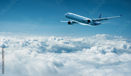 Airplane flies above clouds - air travel photo
