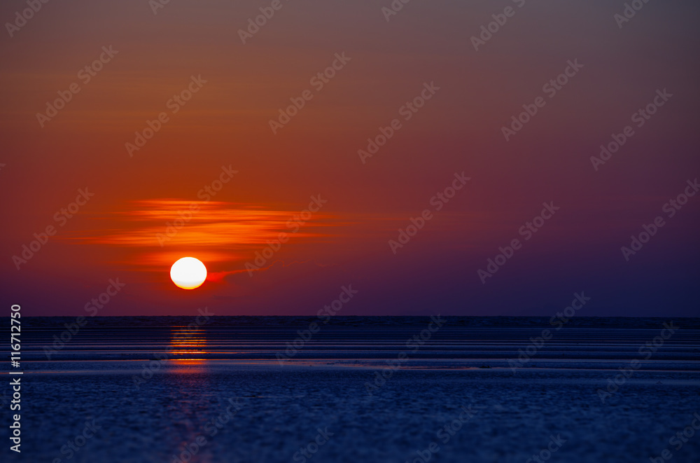 Orange Ball of the Sun Dipping towards Horizon at Sunset