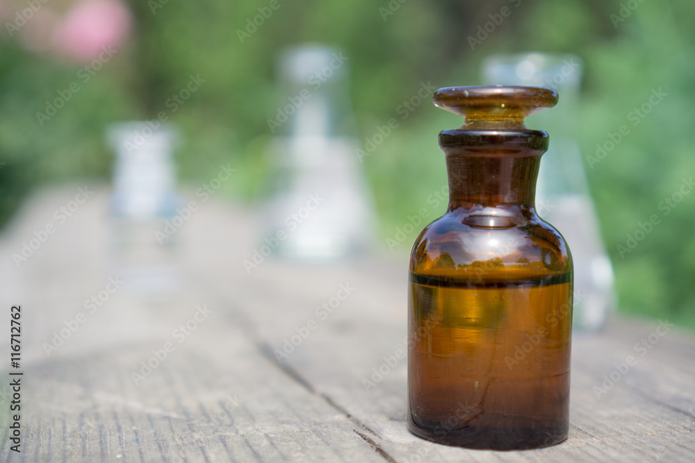 Liquid in chemical ware on a background of plants, fertilizers or pesticides in the garden. Liquid in chemical ware on a background of plants, fertilizers or pesticides in the garden.