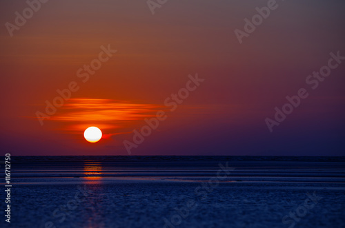 Orange Ball of the Sun Dipping towards Horizon at Sunset