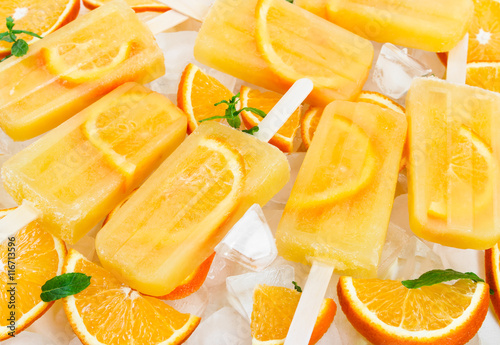 Fruit orange ice lolly on ice cubes