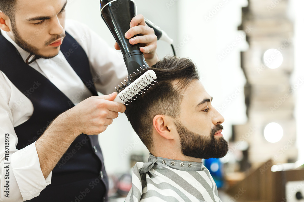 Dark haired barber doing a haircut